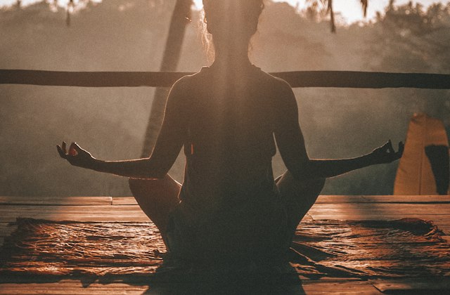 A person meditating as part of a wellness routine